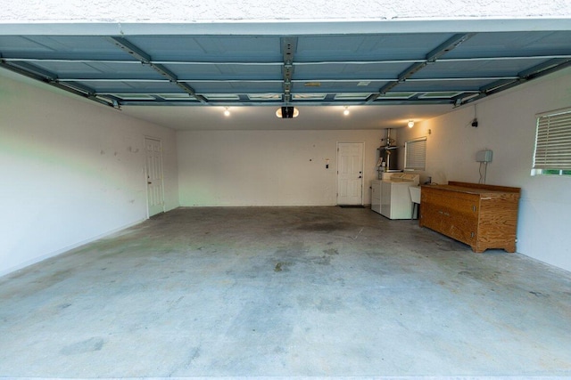 garage featuring washer and clothes dryer, a garage door opener, and strapped water heater