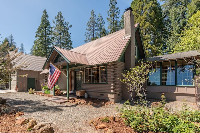 view of front of home with metal roof, log siding, a chimney, and crawl space
