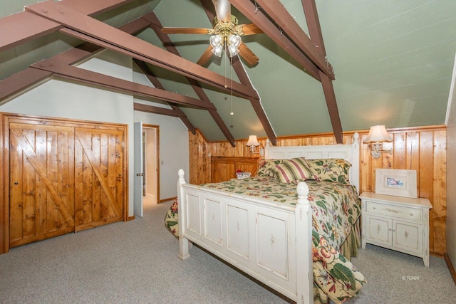 bedroom featuring light carpet, wood walls, and vaulted ceiling with beams