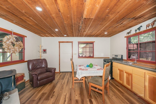 dining space with light wood finished floors, wooden ceiling, a healthy amount of sunlight, and recessed lighting