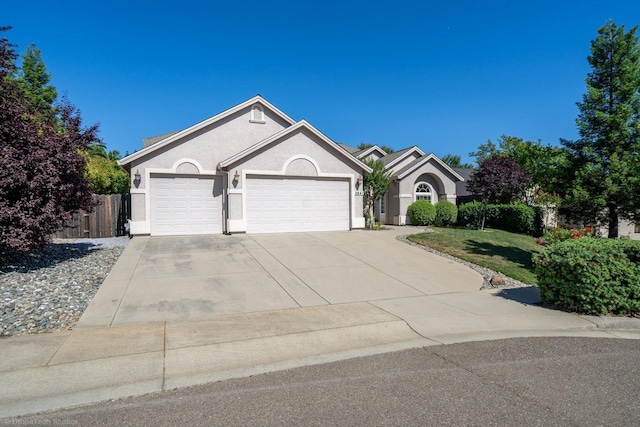 3641 Deuce Way, Redding, CA 96002 - ranch-style home with an attached garage, stucco siding, concrete driveway, and fence