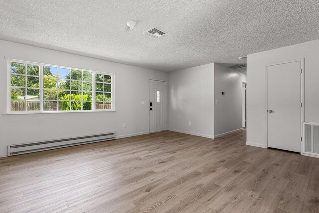 19017 Snowflake Ln, Redding, CA 96003 - spare room with a baseboard radiator, a textured ceiling, light wood-style floors, and baseboards