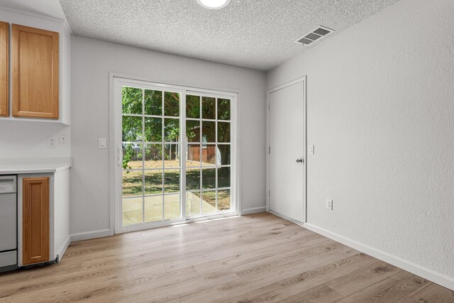 19017 Snowflake Ln, Redding, CA 96003 - unfurnished dining area featuring light wood-style flooring, a textured ceiling, and baseboards