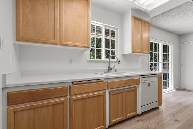 19017 Snowflake Ln, Redding, CA 96003 - kitchen with white dishwasher, a sink, light wood finished floors, light countertops, and a textured ceiling