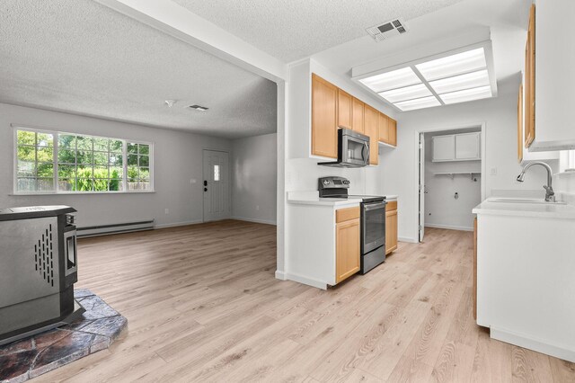 19017 Snowflake Ln, Redding, CA 96003 - kitchen with appliances with stainless steel finishes, a baseboard radiator, a sink, light countertops, and a textured ceiling