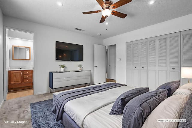 19017 Snowflake Ln, Redding, CA 96003 - bedroom with light colored carpet, a closet, a textured ceiling, recessed lighting, and ensuite bathroom