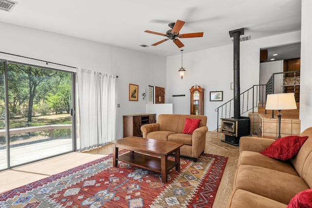 21030 Shangrila Dr, Red Bluff, CA 96080 - living room featuring a wood stove, a ceiling fan, and wood finished floors