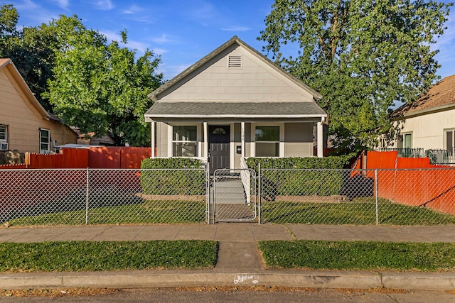 1048 Franklin St, Red Bluff, CA 96080 - bungalow-style home featuring a porch, a gate, a front yard, a fenced front yard, and a shingled roof