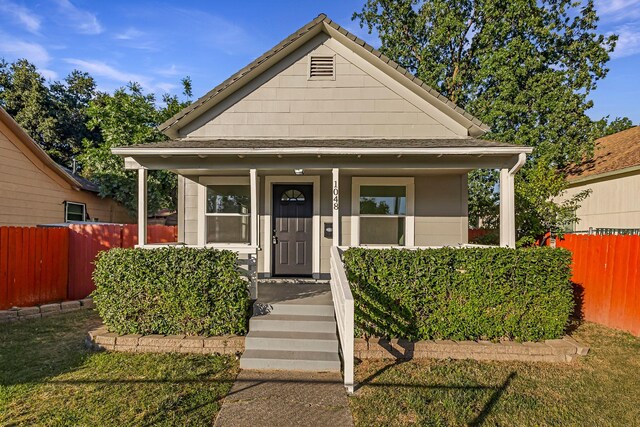 1048 Franklin St, Red Bluff, CA 96080 - bungalow-style home with covered porch, roof with shingles, and fence
