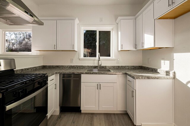 1048 Franklin St, Red Bluff, CA 96080 - kitchen with gas range oven, light wood finished floors, a sink, white cabinetry, and extractor fan