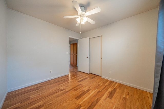 unfurnished bedroom featuring baseboards, light wood-style flooring, a closet, and ceiling fan