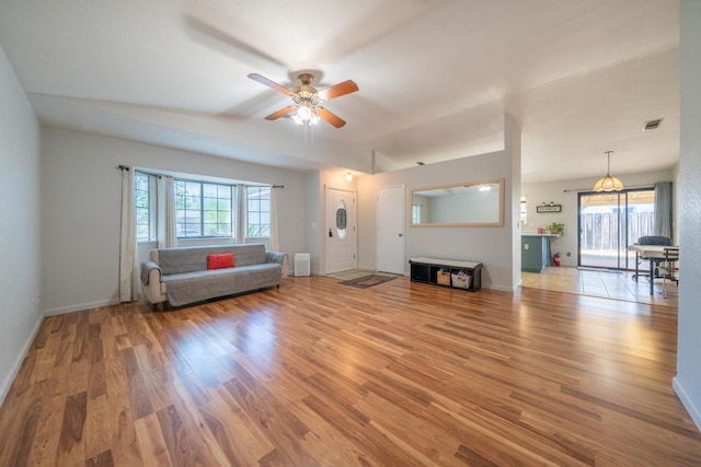 unfurnished living room featuring light wood finished floors, ceiling fan, healthy amount of natural light, and baseboards