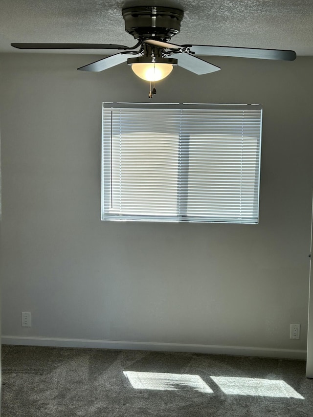 carpeted empty room featuring a textured ceiling, a ceiling fan, and baseboards