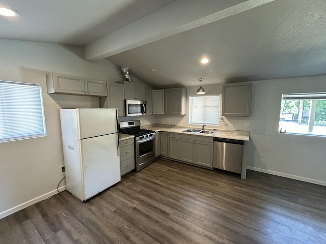 kitchen with appliances with stainless steel finishes, gray cabinets, a sink, light countertops, and dark wood-style floors