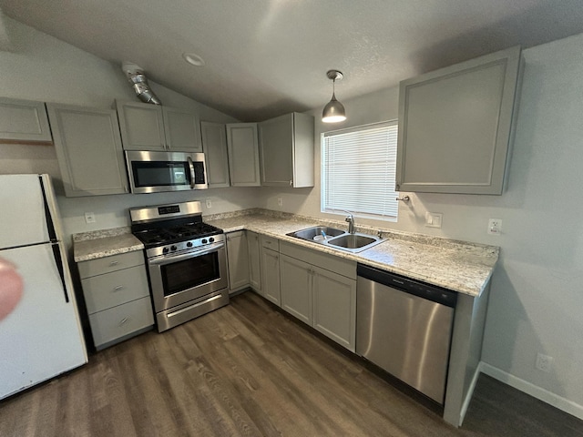 kitchen featuring stainless steel appliances, a sink, dark wood finished floors, vaulted ceiling, and pendant lighting