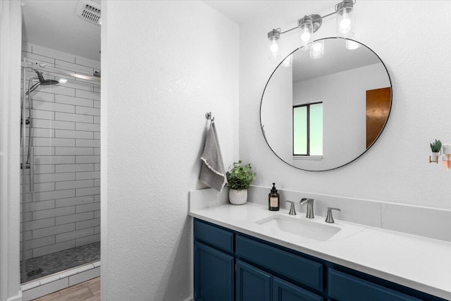bathroom with a shower stall, vanity, and wood finished floors