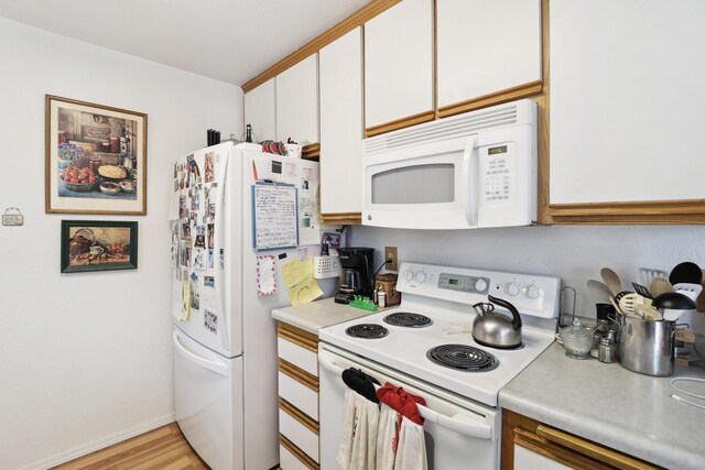 14851 Ravine Rd, Redding, CA 96003 - kitchen with white appliances, light countertops, white cabinetry, light wood-style flooring, and baseboards