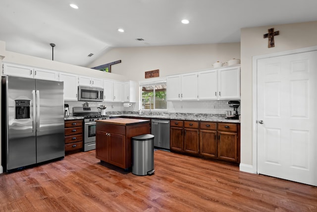 1946 Jeanae Ct, Redding, CA 96002 - kitchen with appliances with stainless steel finishes, white cabinetry, backsplash, high vaulted ceiling, and a kitchen island