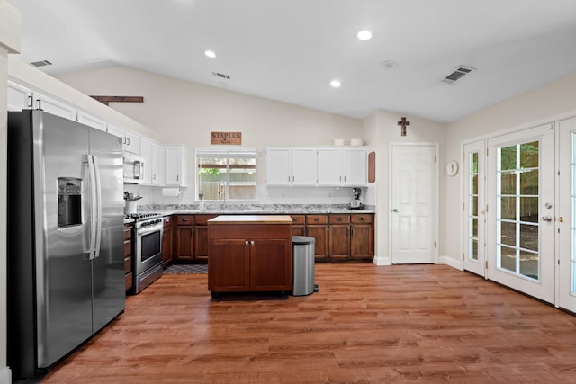 1946 Jeanae Ct, Redding, CA 96002 - kitchen featuring stainless steel appliances, lofted ceiling, white cabinets, light wood finished floors, and a center island