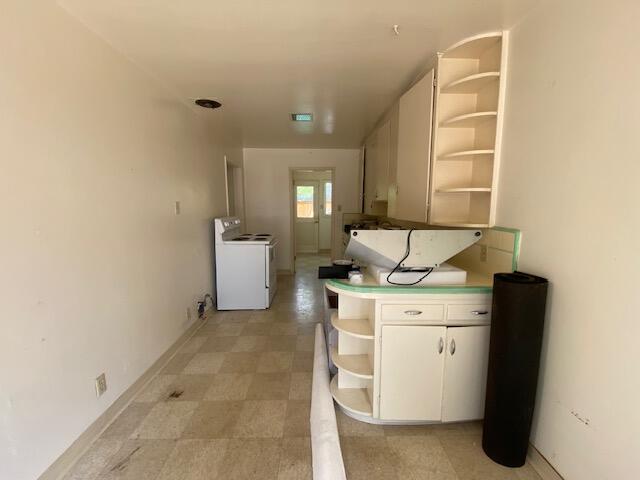 hall featuring washer / clothes dryer and baseboards