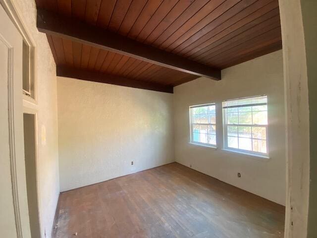 spare room with beam ceiling, wood ceiling, and wood finished floors