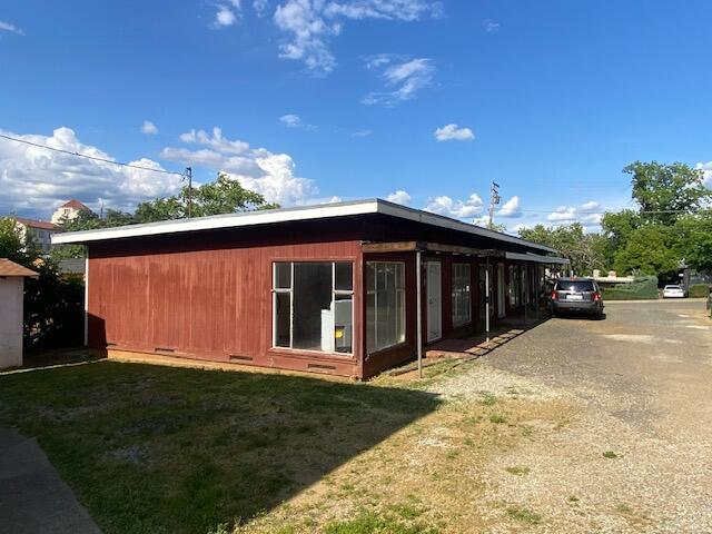 view of side of property featuring a lawn and crawl space