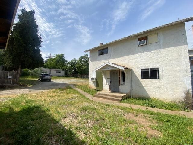 view of front facade with stucco siding and a front lawn