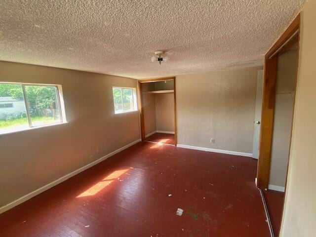 unfurnished bedroom featuring baseboards, a textured ceiling, and a closet