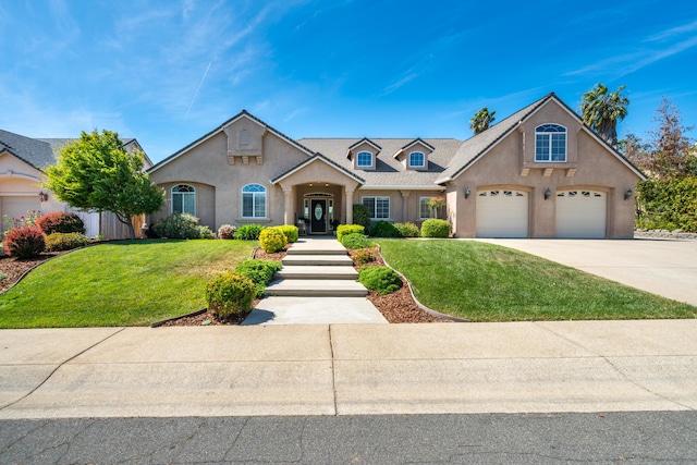 view of front facade with stucco siding, a front lawn, and driveway