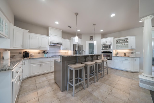 kitchen with stainless steel appliances, tasteful backsplash, ornate columns, a breakfast bar area, and recessed lighting