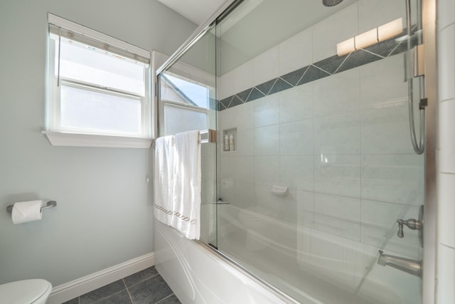 full bathroom featuring shower / bath combination with glass door, tile patterned floors, baseboards, and toilet