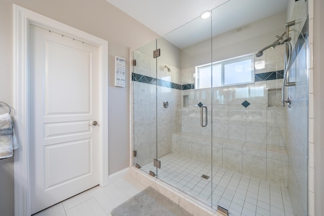 bathroom featuring tile patterned flooring, a shower stall, and baseboards