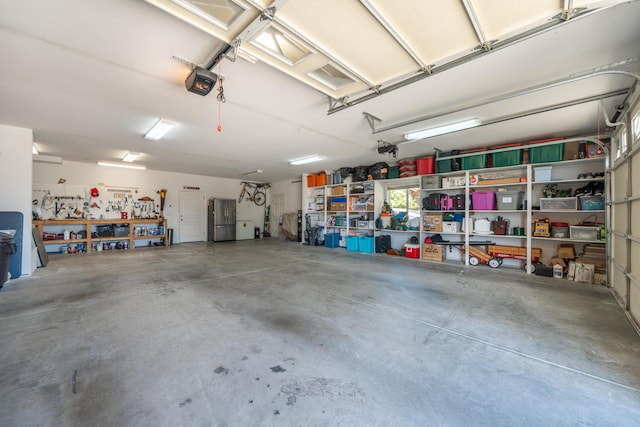 garage featuring freestanding refrigerator and a garage door opener
