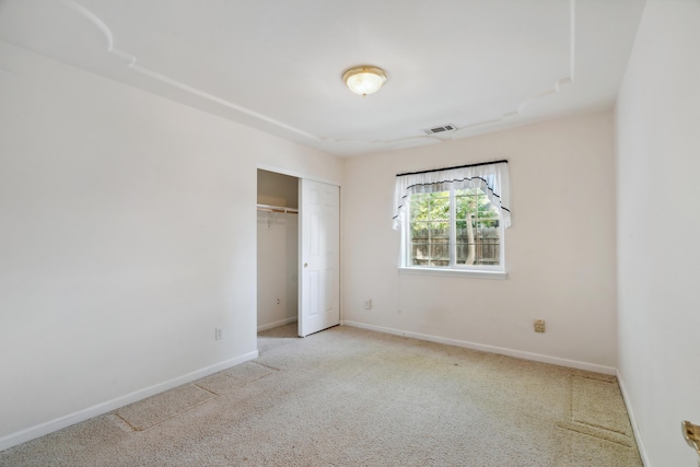 unfurnished bedroom featuring carpet, baseboards, and a closet