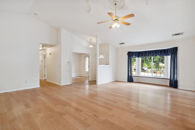 unfurnished living room with ceiling fan, light wood finished floors, high vaulted ceiling, and baseboards