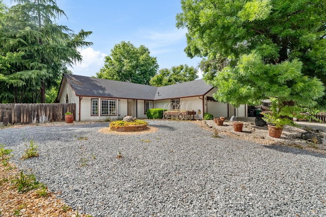 single story home with fence, gravel driveway, roof with shingles, and a garage