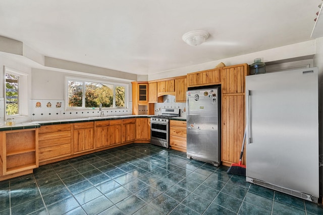 8686 Bell Springs Rd, Garberville, CA 95542 - kitchen featuring appliances with stainless steel finishes, tasteful backsplash, tile counters, a sink, and dark tile patterned flooring