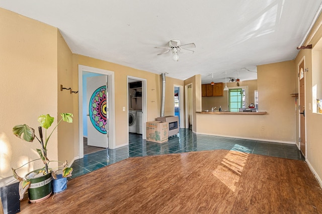 8686 Bell Springs Rd, Garberville, CA 95542 - living room with washer / clothes dryer, dark tile patterned flooring, a ceiling fan, baseboards, and a wood stove