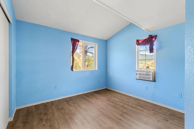 8686 Bell Springs Rd, Garberville, CA 95542 - unfurnished room featuring vaulted ceiling, wood finished floors, a textured wall, baseboards, and cooling unit