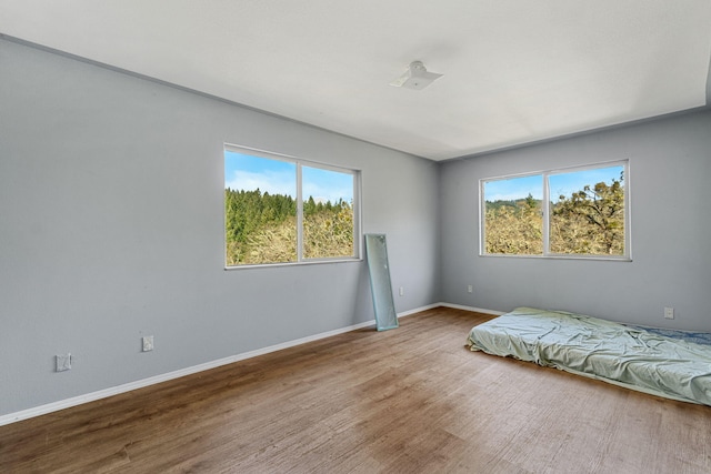 8686 Bell Springs Rd, Garberville, CA 95542 - bedroom featuring multiple windows, wood finished floors, and baseboards