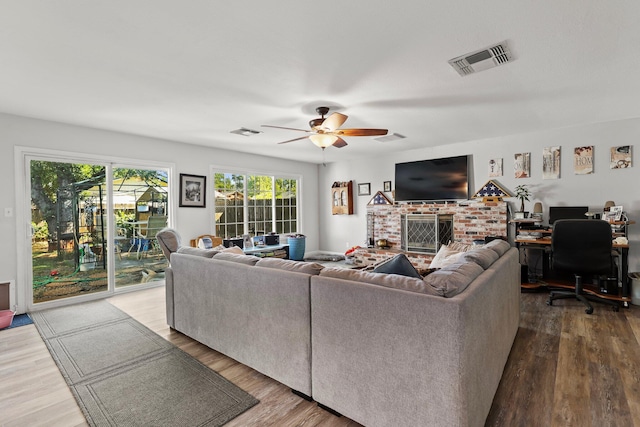 2350 Christian Ave, Redding, CA 96002 - living room with a ceiling fan, wood finished floors, a desk, and a brick fireplace