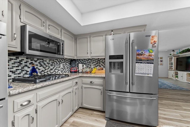 7597 Terra Linda Way, Redding, CA 96003 - kitchen featuring appliances with stainless steel finishes, light wood-style flooring, light countertops, and tasteful backsplash