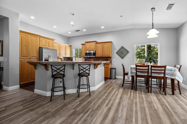 406 Spire Point Dr, Redding, CA 96003 - kitchen with stainless steel appliances, wood finished floors, a breakfast bar, and recessed lighting
