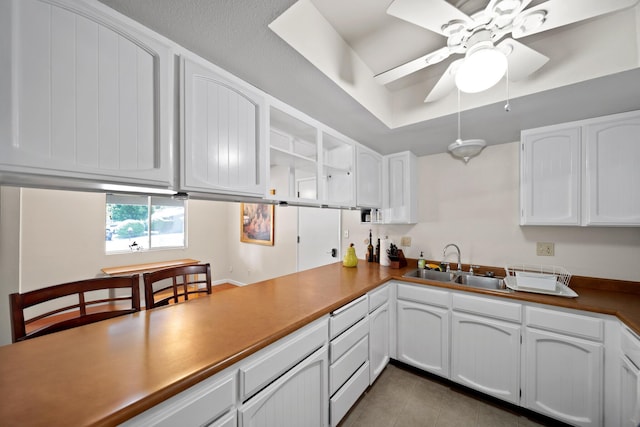 1836 Del Mar Ave, Redding, CA 96003 - kitchen with white cabinets, light tile patterned floors, a ceiling fan, and a raised ceiling