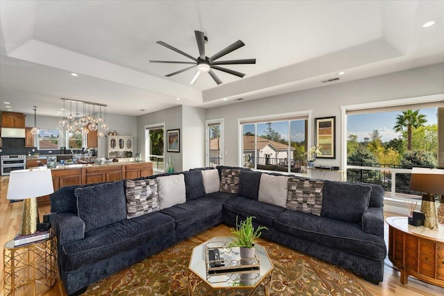 1235 Chandon Ct, Redding, CA 96003 - living area featuring a tray ceiling, light wood-style flooring, recessed lighting, and ceiling fan