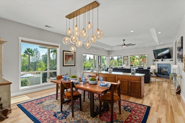 1235 Chandon Ct, Redding, CA 96003 - dining room featuring a fireplace, healthy amount of natural light, light wood-style flooring, ceiling fan, and recessed lighting
