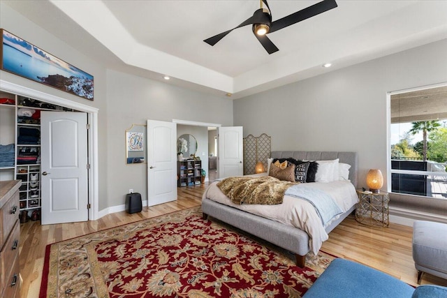 1235 Chandon Ct, Redding, CA 96003 - bedroom featuring wood finished floors, a ceiling fan, a closet, a raised ceiling, and baseboards