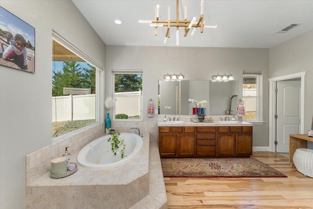 1235 Chandon Ct, Redding, CA 96003 - bathroom with a chandelier, a whirlpool tub, wood finished floors, and double vanity