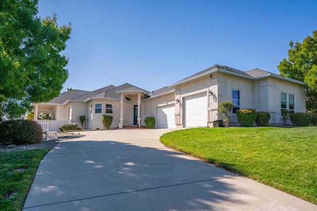 1235 Chandon Ct, Redding, CA 96003 - view of front of house featuring an attached garage, a front lawn, stucco siding, and concrete driveway