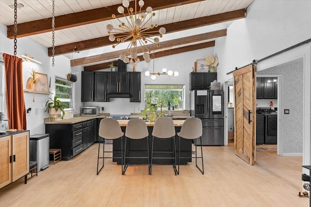 19697 Old Indian Trl, Redding, CA 96003 - kitchen with appliances with stainless steel finishes, dark cabinets, a chandelier, wooden ceiling, and a barn door